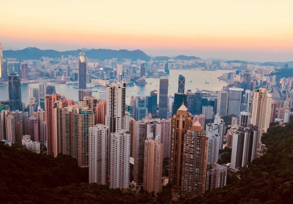 Breathtaking Kowloon skyline with skyscrapers and harbor at sunset, showcasing Hong Kong's urban beauty.
