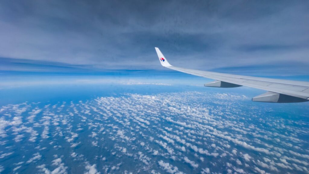 Stunning aerial view of clouds from an airplane window showcasing wing and sky.